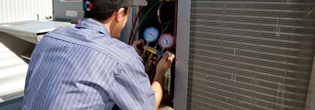 HVAC technician servicing a condenser unit in Fair Oaks Ranch