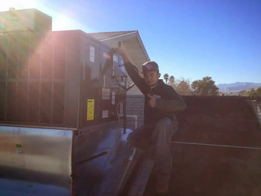 HVAC technician performing Air Duct Cleaning on a rooftop unit in Fair Oaks Ranch